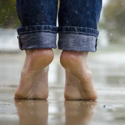 Bare feet standing on a wet surface at the beach, representing everyday foot health